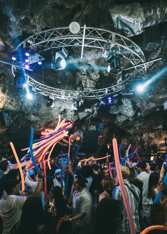 Festa de despedida de solteiro dentro da caverna da Imagine Punta Cana, com público animado e iluminação cênica