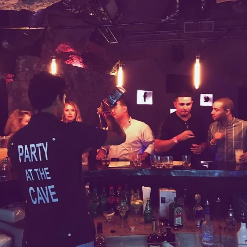 Bartender doing bottle flair behind the bar at Imagine Punta Cana, nightclub inside a natural cave in Bávaro
