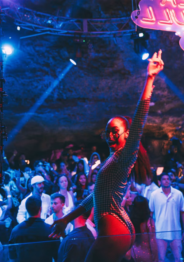 Dancer performing on stage with red lighting at Imagine Punta Cana, the natural cave nightclub